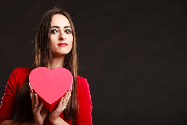 Flickan i rött håller hjärta låda. — Stockfoto