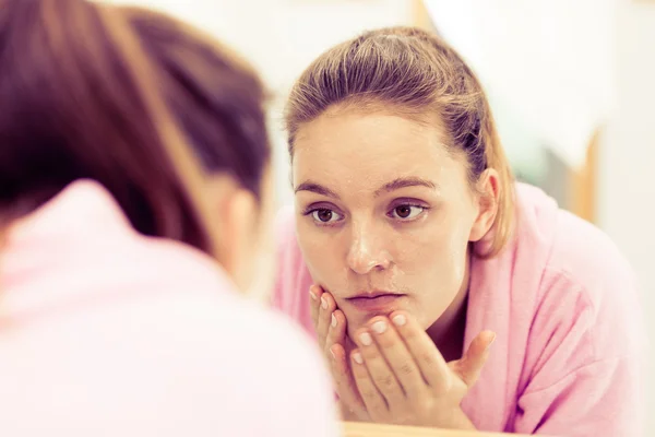 Mujer limpiando su cara con exfoliante en el baño . — Foto de Stock