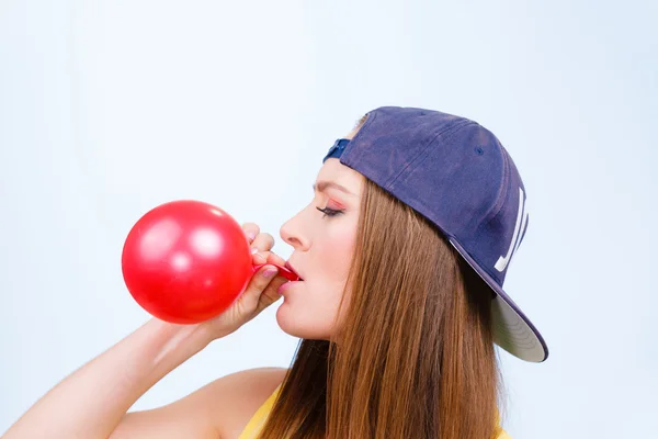 Chica soplando globo rojo — Foto de Stock