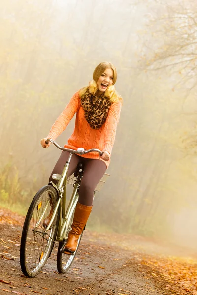 Active woman riding bike in autumn park. — Stock Photo, Image