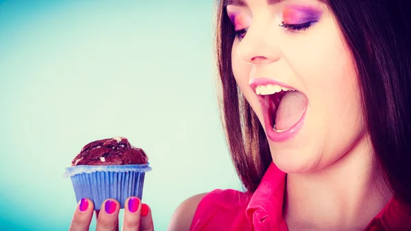 Leende kvinna håller chokladtårta i handen — Stockfoto
