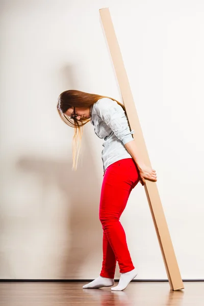 Mujer mudándose a apartamento llevando pesada caja . —  Fotos de Stock