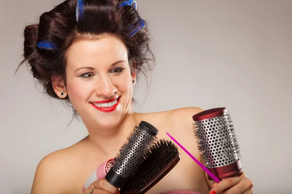 Funny girl styling hair holds many accessories — Stock Photo, Image