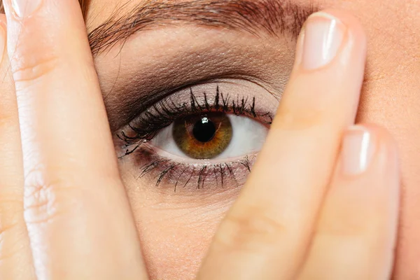 Mujer cubrir la cara mirada a través de los dedos . — Foto de Stock