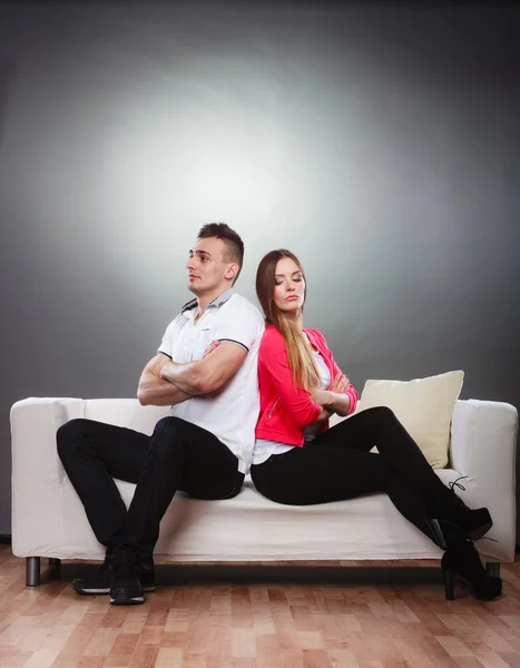 Young couple after quarrel sitting on sofa back to back — Stock Photo, Image