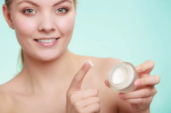 Mulher aplicando creme no rosto da pele . — Fotografia de Stock