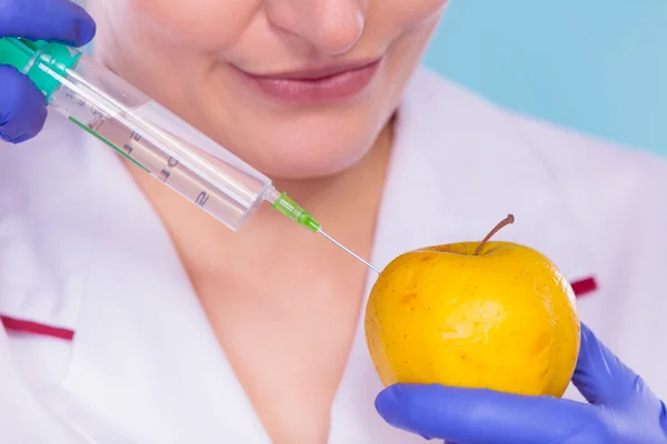 Wetenschapper arts injecteren apple. Genetisch gemodificeerde levensmiddelen. — Stockfoto