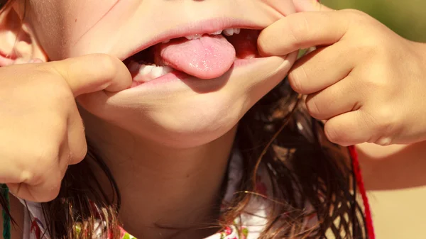 Close-up-Kind macht dummes Gesicht, das die Zunge herausstreckt — Stockfoto