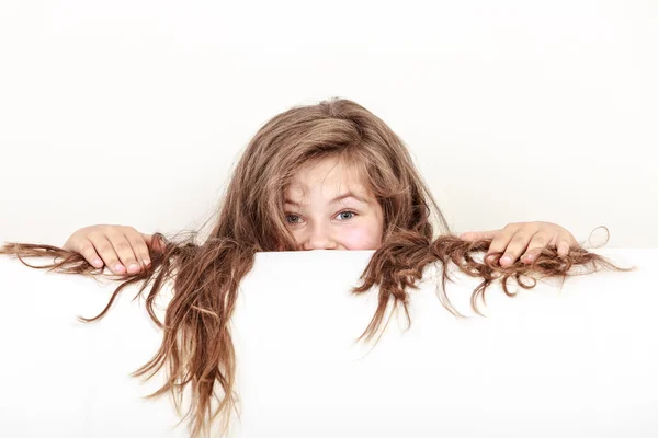 Malá dívka s dlouhými vlasy drží prázdný nápis. — Stock fotografie
