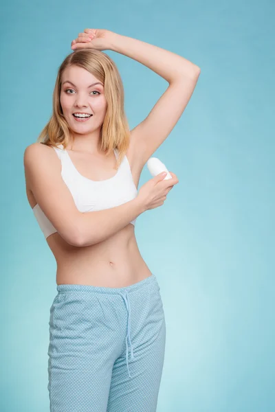 Menina aplicando desodorizante vara na axila. — Fotografia de Stock