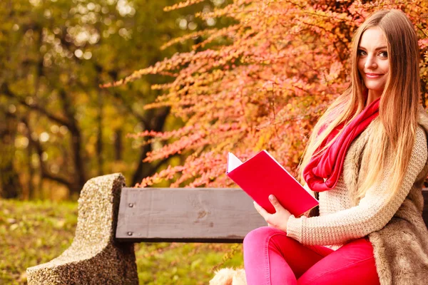 Frau entspannt sich im herbstlichen Park beim Lesen von Buch — Stockfoto