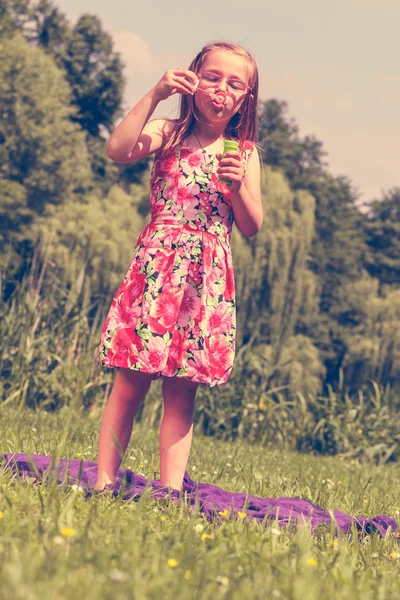 Petite fille enfant soufflant des bulles de savon extérieur . — Photo