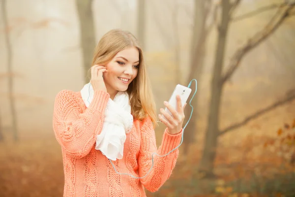 Frau mit Kopfhörern hört Musik im Park. — Stockfoto