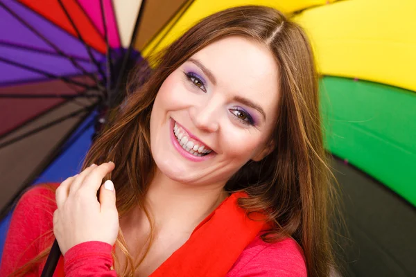 Женщина, стоящая под разноцветным зонтом — стоковое фото