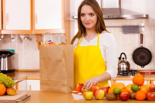 Mulher dona de casa na cozinha com muitos frutos — Fotografia de Stock