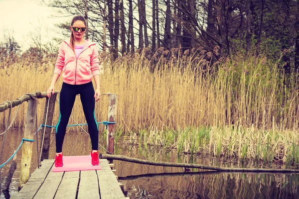 Dziewczyna, szkolenia sportowe ubrania na brzegu jeziora — Zdjęcie stockowe