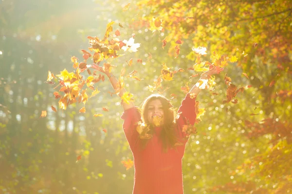 Mulher brincando com folhas outonais . — Fotografia de Stock