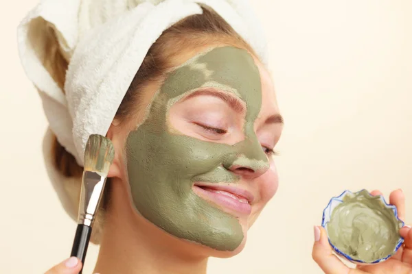 女性が彼女の顔にブラシ粘土泥マスクを適用します。 — ストック写真