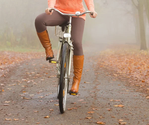 Active woman riding bike in autumn park. — Stock Photo, Image