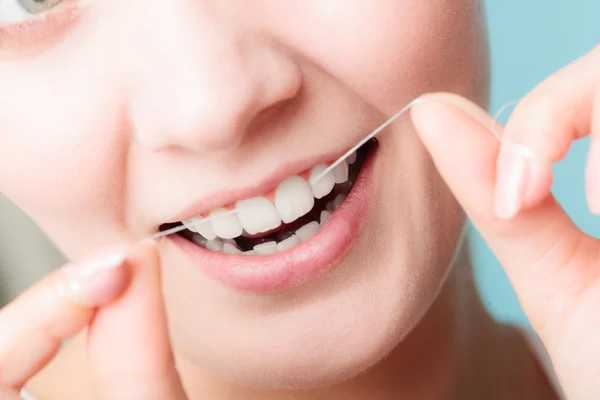 Wanita tersenyum dengan benang gigi. — Stok Foto