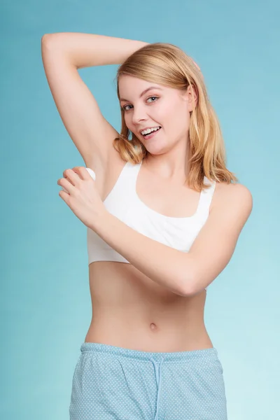 Meisje aanbrengen stok deodorant in oksel. — Stockfoto