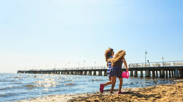 Mutter und Tochter spielen am Strand. — Stockfoto