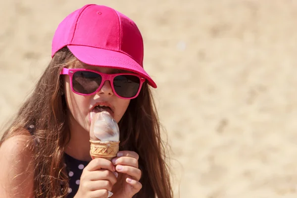 Kis lány gyerek eszik fagylaltot a strandon. Nyári. — Stock Fotó