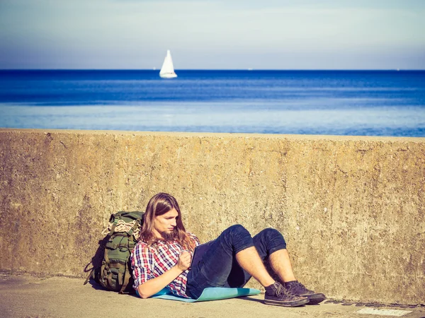 Touristischer Backpacker sitzt mit Tablet im Freien — Stockfoto