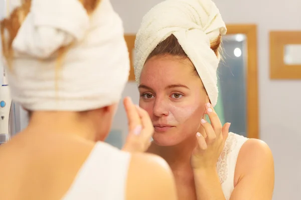 Donna che applica crema maschera sul viso in bagno — Foto Stock