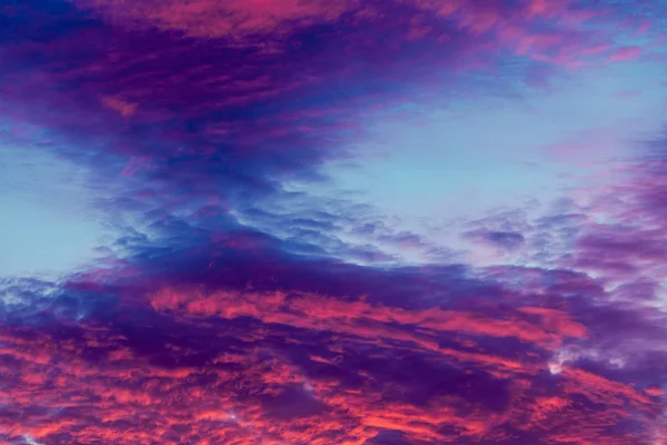 Färgglada pulserande moln på himlen vid solnedgången — Stockfoto