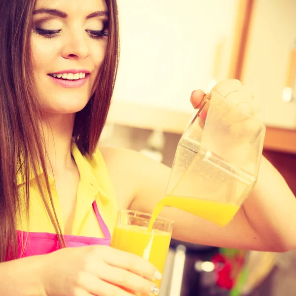 Mulher fazer suco de laranja na máquina juicer derramando bebida em vidro — Fotografia de Stock