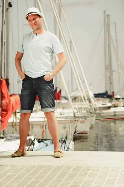 Handsome fashion man on pier in port with yachts. — Stock Photo, Image