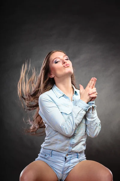 Frau hat Spaß und täuscht vor, dass der Finger eine Waffe ist. — Stockfoto