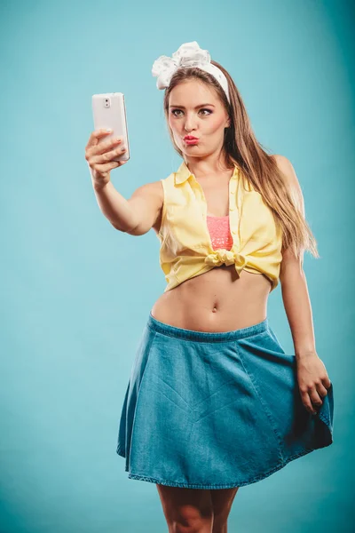 Retro flicka med smartphone tar selfie — Stockfoto