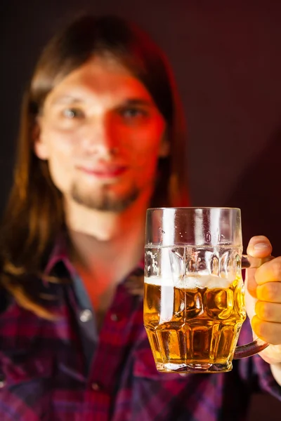 Handsome young man holding a mug of beer — Stock Photo, Image