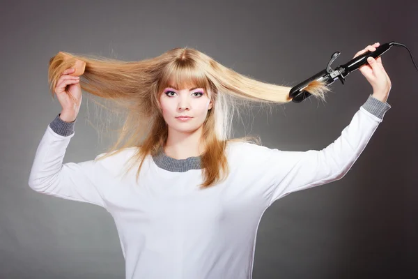 Mulher fazendo penteado com ferro de cabelo — Fotografia de Stock