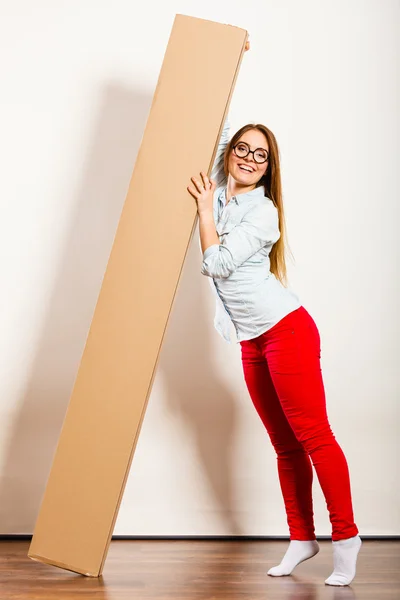 Happy woman moving into apartment carrying box. — Stock Photo, Image