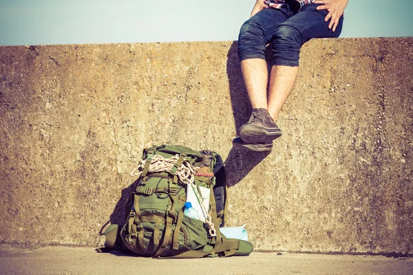 Grunge duvarda açık oturan adam turist backpacker — Stok fotoğraf