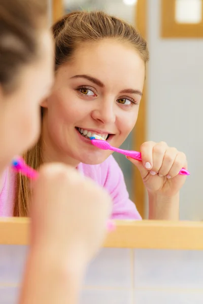 Mulher escovando os dentes de limpeza no banheiro — Fotografia de Stock