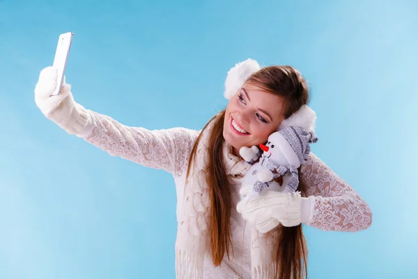 Vrouw met kleine sneeuwpop nemen selfie foto. — Stockfoto