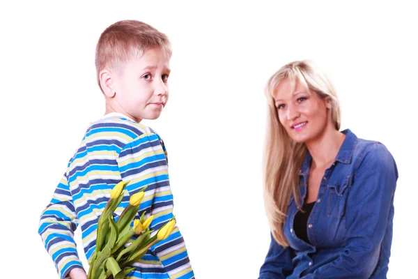 Liten pojke med mamma hålla blommor bakom rygg. — Stockfoto