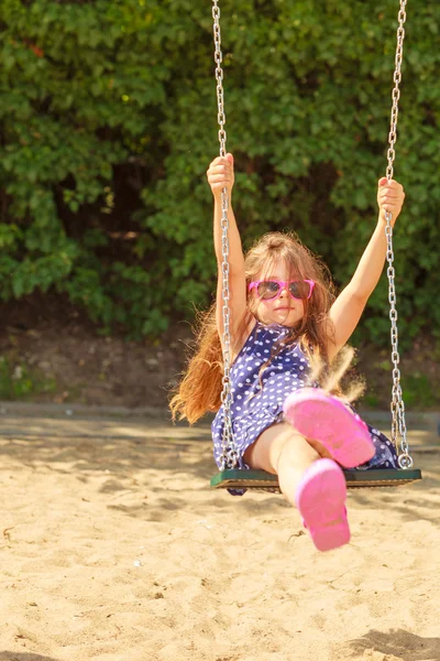 Girl swinging on swing-set. — Stock Photo, Image