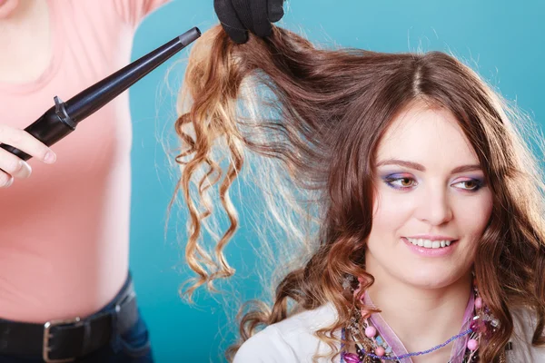 Hairdresser curling woman hair with iron curler. — Stock Photo, Image