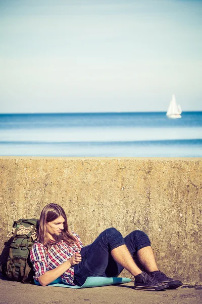 Man turist backpacker sitter med tablett utomhus — Stockfoto