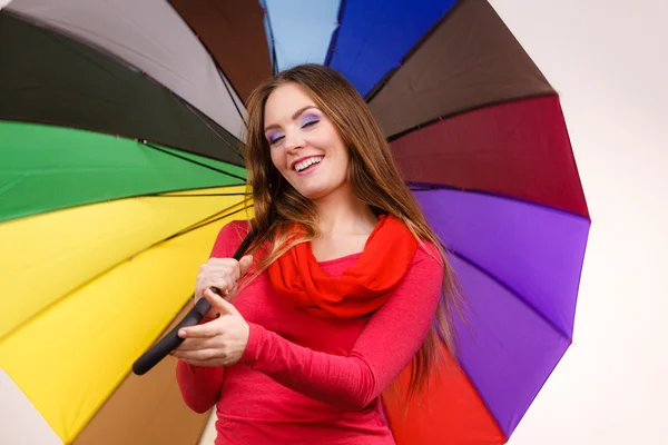 Woman standing under multicolored umbrella — Stock Photo, Image