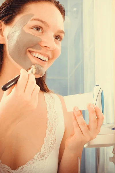 Mujer aplicando máscara facial de barro —  Fotos de Stock