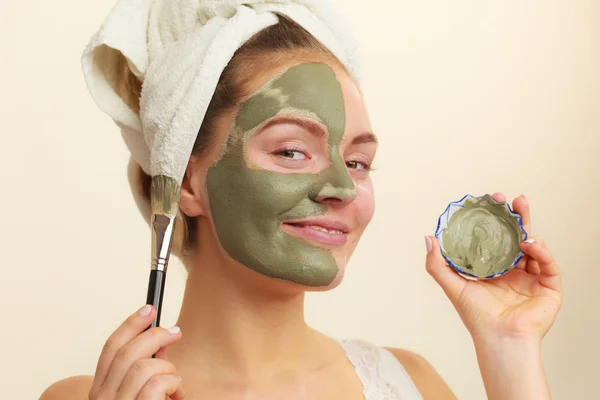 Femme appliquant avec un masque de boue d'argile brosse sur son visage — Photo