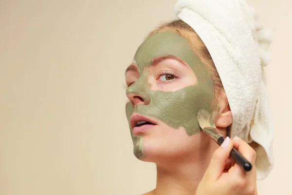 Woman applying with brush clay mud mask to her face — Stock Photo, Image