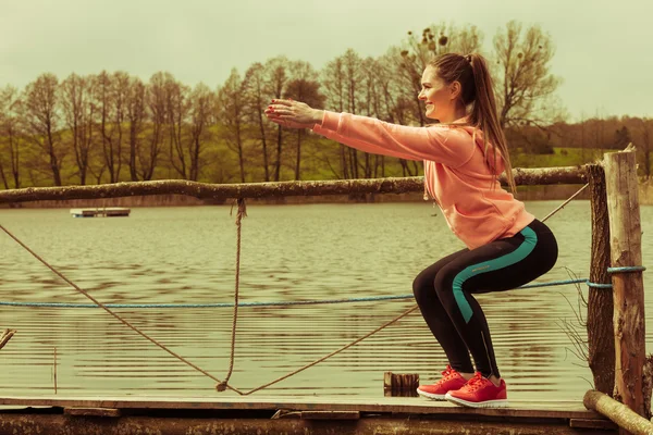 Chica de entrenamiento en ropa deportiva en la orilla del lago —  Fotos de Stock