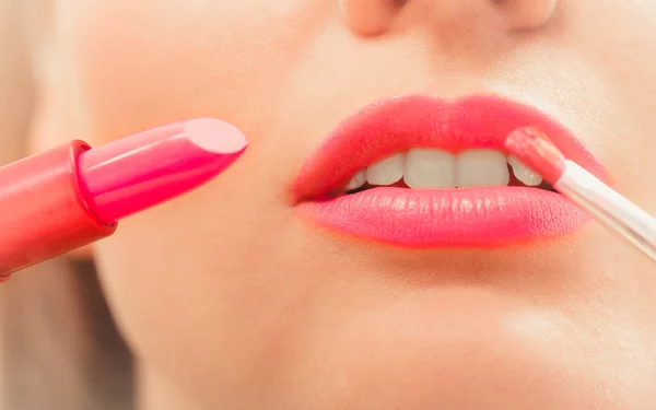 Vrouw die lippenstift met borstel op de lippen aanbrengt. Make-up — Stockfoto